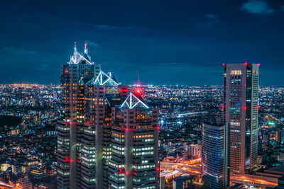 Illuminated cityscape against sky at night