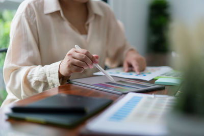 Midsection of businesswoman working at table