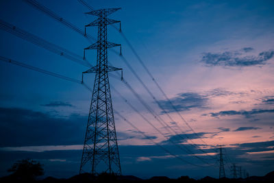 Low angle view of silhouette electricity pylon against sky during sunset