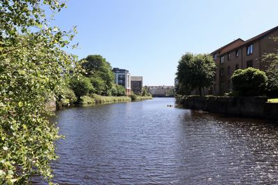 River amidst buildings against clear sky