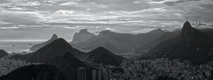 Panoramic view of buildings against cloudy sky