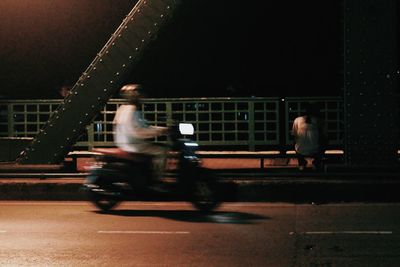 Blurred motion of people on road at night