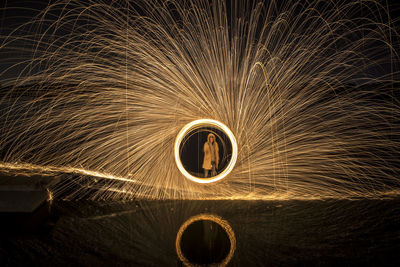Man standing amidst wire wool at night