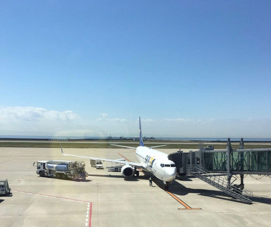 airplane, transportation, airport runway, airport, passenger boarding bridge, day, stationary, sky, outdoors, air vehicle, no people