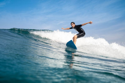 Full length of man surfing in sea against sky