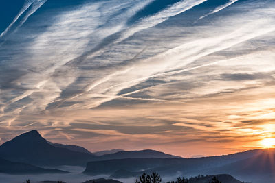 Scenic view of snowcapped mountains against sky during sunset