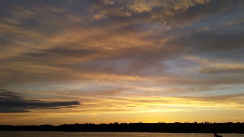 Scenic view of dramatic sky over silhouette landscape