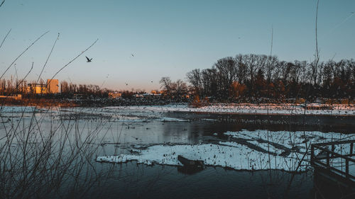 Scenic view of lake against clear sky during winter