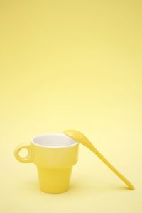 Close-up of coffee cup against yellow background