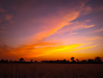 Scenic view of field against romantic sky at sunset