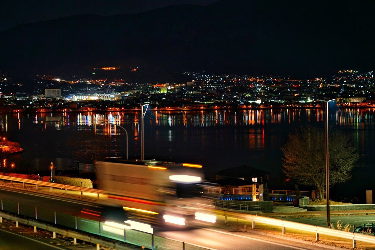 ILLUMINATED CITY AGAINST SKY AT NIGHT