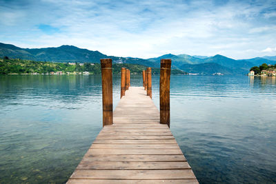 Wooden pier in lake against sky
