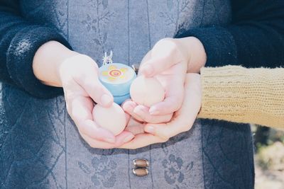 Cropped image of child with mother holding easter eggs
