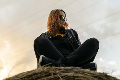 Woman wearing sunglasses sitting outdoors