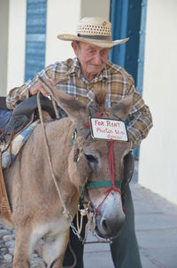 Man with donkey walking on sidewalk