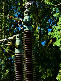 Low angle view of machinery against trees