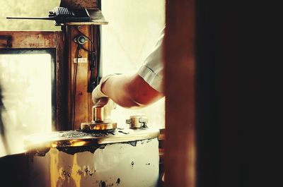 Cropped image of worker operating machine in workshop