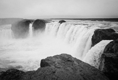 Scenic view of waterfall against sky