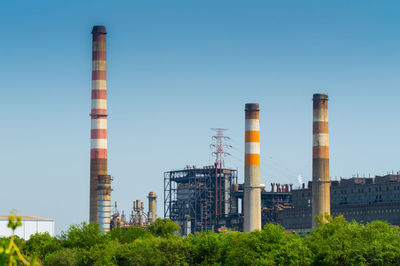 Low angle view of factory against clear blue sky