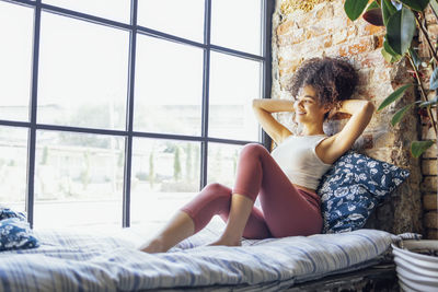 Young woman sitting on bed