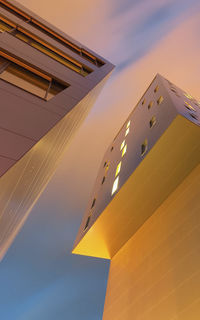 Low angle view of modern building against sky during sunset