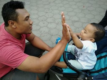 High angle view of father playing with cute son