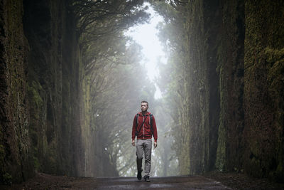 Full length portrait of man standing in forest