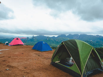 Tourist tent camping on mountains with rain storm and cloudy sky background