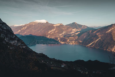 Scenic view of lake by mountains against sky