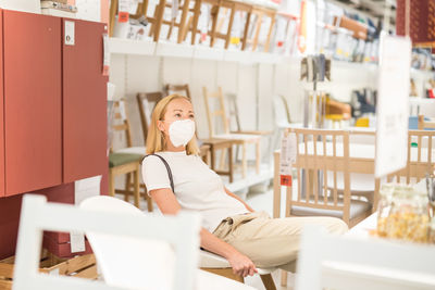 Mid adult woman wearing mask standing in supermarket