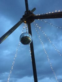 Low angle view of lighting equipment hanging against sky