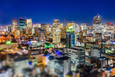 Illuminated buildings in city against sky