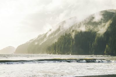 Scenic view of sea and mountains against sky