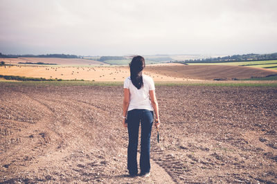 Rear view of woman standing on field