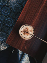 Cropped image of man holding coffee on table