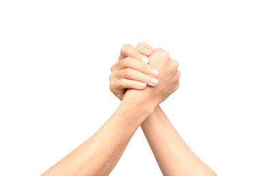 Close-up of arms wrestling against white background