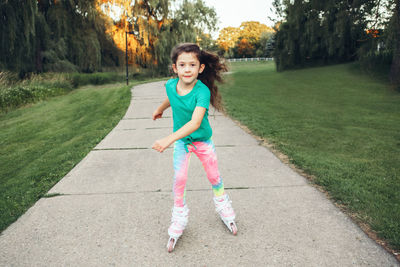 Full length of girl wearing mask skating on footpath at park