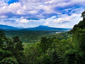 Scenic view of green landscape and mountains against sky