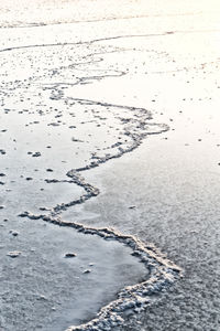 High angle view of footprints on frozen water