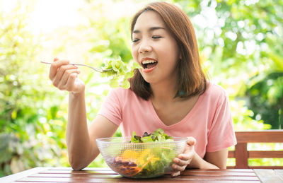 Young woman eating food on table