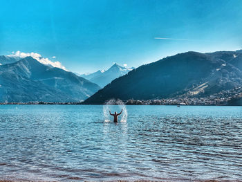 Scenic view of sea by mountains against sky