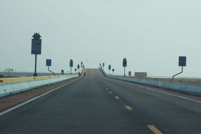 Vehicles on road against clear sky