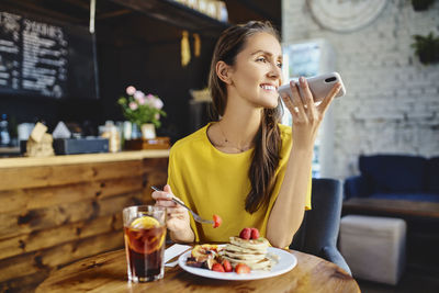 Young woman sitting at restaurant table