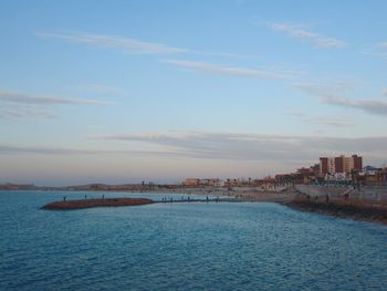 Scenic view of sea and buildings against sky