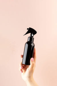 A mockup of a professional hair product in a brown pulvilizer in a woman's hand 