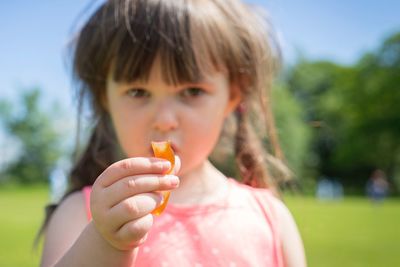 Close-up portrait of girl holding snack