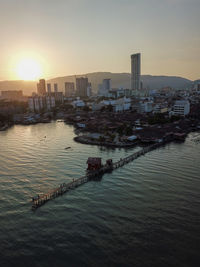 View of buildings at waterfront during sunset