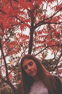 Portrait of woman standing against tree during autumn