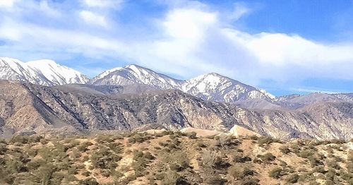 Scenic view of mountains against cloudy sky