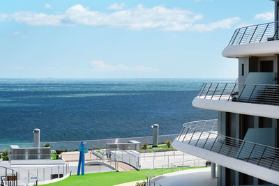 Scenic view of sea by buildings against sky